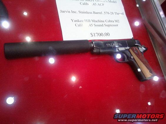 Colt M1911 pistol with sound suppressor and price tag