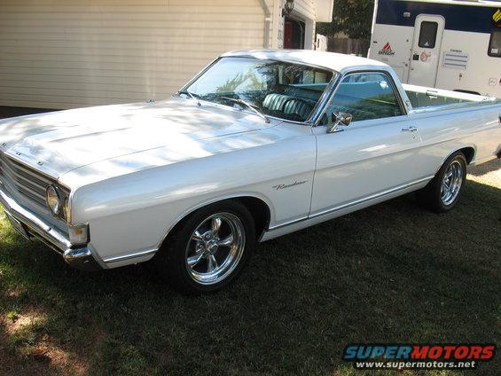 White 1969 Ford Ranchero with chrome wheels parked on grass