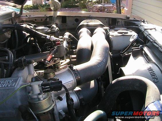 1985 Ford Bronco engine bay with air intake and hoses visible