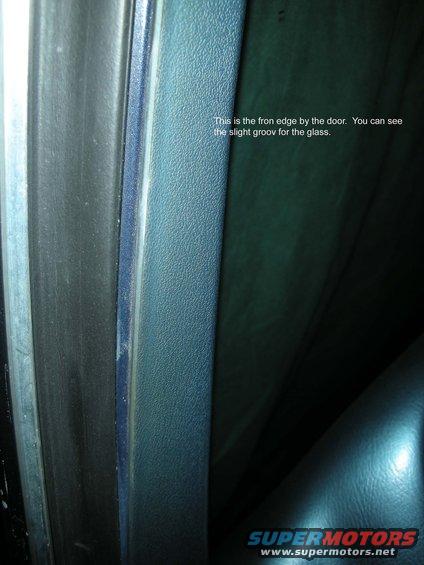 Close-up of a blue interior door frame with a rubber seal and a groove for glass