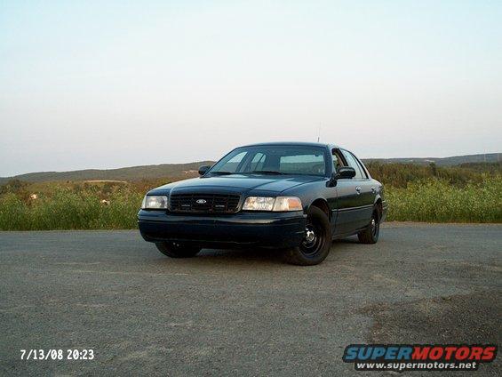 Dark blue 1998 Ford Crown Victoria sedan parked on a paved road, front 3/4 view
