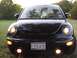 1999 Volkswagen Beetle - The front of a black Volkswagen Beetle is shown with its headlights and fog lights illuminated.