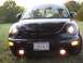 1999 Volkswagen Beetle - A black Volkswagen Beetle is parked outdoors, facing the camera with its headlights and fog lights illuminated.