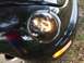 1999 Volkswagen Beetle - Close-up of the front corner of a black 1999 Volkswagen Beetle, showing the headlight and turn signal.