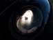 1999 Volkswagen Beetle - A close-up view of the illuminated headlight on a black 1999 Volkswagen Beetle.