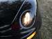 1999 Volkswagen Beetle - The front corner of a black car is shown, focusing on the headlight and turn signal assembly.