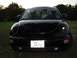 1999 Volkswagen Beetle - A black Volkswagen Beetle is parked outdoors, facing the camera with its headlights on.