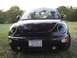1999 Volkswagen Beetle - Black 1999 Volkswagen Beetle parked outdoors with trees in the background.