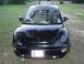 1999 Volkswagen Beetle - This black Volkswagen Beetle is parked outdoors on a grassy area with trees in the background.