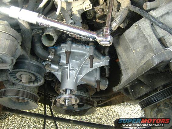 wp11.jpg New pump on and tightened.  Torque on the water pump bolts said 12 to 18 ft/lbs, so I dialed in 15 on the torque wrench.  Same goes for the fan bolts you see temporarly screwed into the spindle on the new pump.  Take the little hose off before you put the new pump on.  Put it on the pump first (leave the lower, longer one off to the side) and slowly move the pump in place.  You've got the RTV'd up gasket on the back, so don't bump and distrupt the gasket.  I put the top two bolts in beforehand and guded it that way.  Secured those and quickly threaded two bottom bolts so the pump was in place.  In a star pattern, snug all the bolts with the ratchet, then clamp them down with the torque wrench.  New piece of hardware looks good.  Now on to the rest of the engine....probably later than sooner....
Start putting the things back together.  First remount the two pump bracket.  Like I said, be careful, it's bulky, but not that bad.  Once that's locked down, put the belt pulley on the water pump spindle.  Put the serpentine belt on before you try putting the fan back on and tightening those bolts.  With the belt in place, the tension and me holding the belt pulley was enough to clamp down the fan bolts.  Once the fan is to your liking, then it's hoses and fan shroud.  And 3 bottles of coolant.  Let it sit overnight before you fill up the coolant and turn it on.  Let the RTV cure.  I tested mine this afternoon, about 24 hrs.  Let it idle up to normal op temp, no issues.  Test drive...nothing.  Looks good.  They did say that on new water pumps, the first time you run the engine, the weep hole may leak a little for a short while.  Mine didn't.  We'll see...it's back to the grind tomorrow...hopefully my next weekend  will be a different project , not revisiting this one....