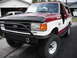 1991 Ford Bronco - This two-tone 1991 Ford Bronco features an aggressive aftermarket bumper and side steps, suggesting off-road capability.
