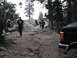 1991 Ford Bronco - A group of people hike up a , rocky trail with a black truck partially visible on the right side of the frame.