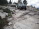 1991 Ford Bronco - Two modified off-road vehicles tackle a challenging rocky path in a mountainous area.