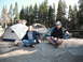 1991 Ford Bronco - Two men relax near tents in a wooded campsite.