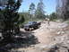1991 Ford Bronco - A modified Ford F-Series truck navigates a challenging off-road path surrounded by trees and rocks.