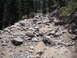 1991 Ford Bronco - A rocky mountain trail shows tire tracks winding through the boulders and trees.