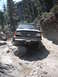 1991 Ford Bronco - This 1991 Ford Bronco is shown tackling a challenging off-road path with large rocks and steep inclines.