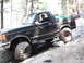 1991 Ford Bronco - Driver navigates a black 1991 Ford Bronco over rocks on an off-road trail.