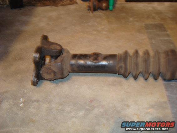 Driveshaft with U-joints and rubber boot on concrete floor