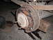 1991 Ford Bronco - Close-up of a vehicle's rear drum brake assembly, supported by a jack and wooden block.