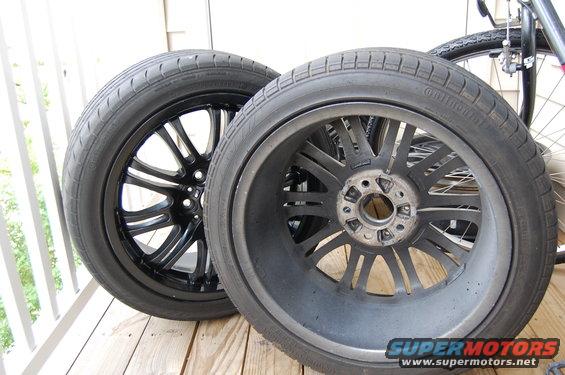 Two car wheels with tires; one is black with a multi-spoke design, the other is gray and shows the hub