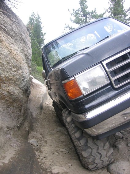 Dark Ford truck navigating a narrow rocky trail