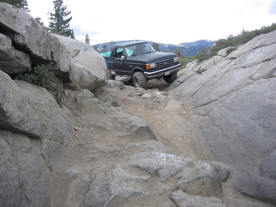 Black Ford F-Series truck navigating a rocky trail