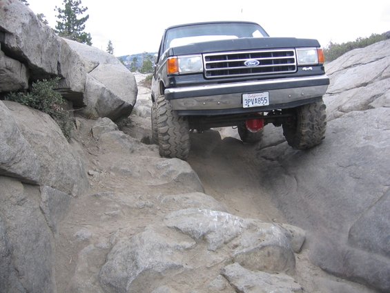 Ford F-Series truck navigating a steep, rocky trail. License plate 3PVA855
