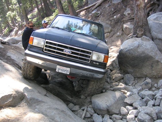 Black Ford F-Series truck with 4x4 badge navigating rocks