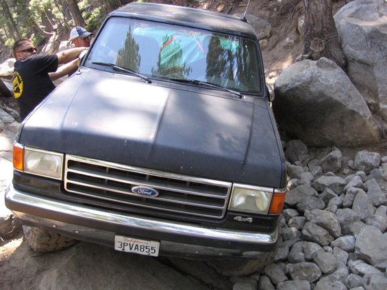 Black 1989 Ford Bronco front view navigating rocky terrain