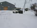 1990 Ford Bronco - A white Bronco with a black hood is stuck in deep snow near a large building.