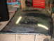 1992 Ford Taurus - A detached car hood shows significant wear and tear, with areas of paint damage and dirt accumulation of dust.
