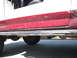 1991 Ford Bronco - The side view of a red and white SUV reveals its running boards and lower body panels.