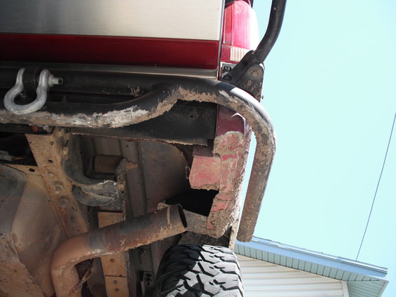 Red 1991 Ford Bronco rear bumper with tow hitch and spare tire visible