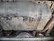 1991 Ford Bronco - The underside of a vehicle shows a heavily soiled fuel tank and exhaust components.