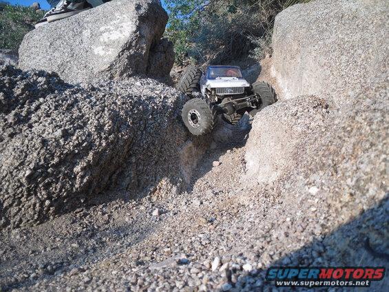 RC crawler truck with large tires climbing over rocks