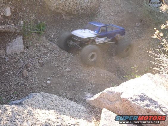 RC rock crawler truck with big tires going over rocks and dirt