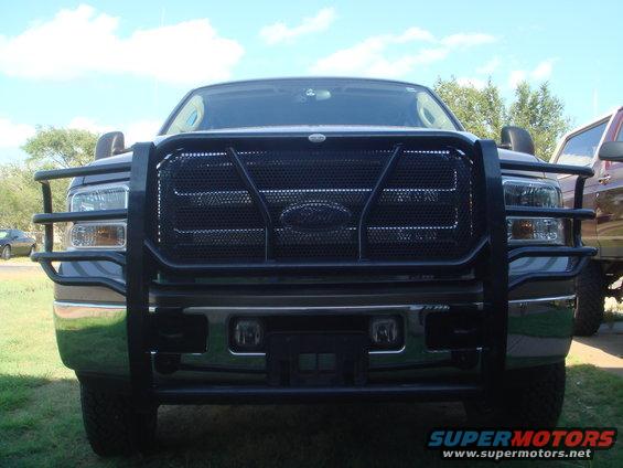 Front view of a truck with a black grille guard. Another vehicle is visible to the right
