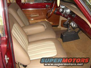 Car interior with two-tone seats, wood-grain door panel, and steering wheel. Watermark "SUPERMOTORS www.supermotors.net" is visible