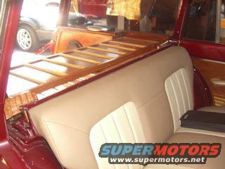 Red station wagon interior with wood paneling and tan seats, showing a partial view of another vehicle outside