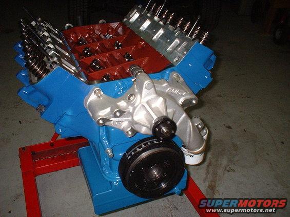 Blue and red Ford V8 engine assembly on a red stand