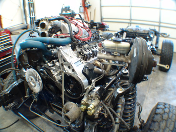 Engine assembly with blue hoses, silver intake manifold, and red spark plug wires