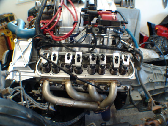 Close-up of a V8 engine with exposed valve train and exhaust headers