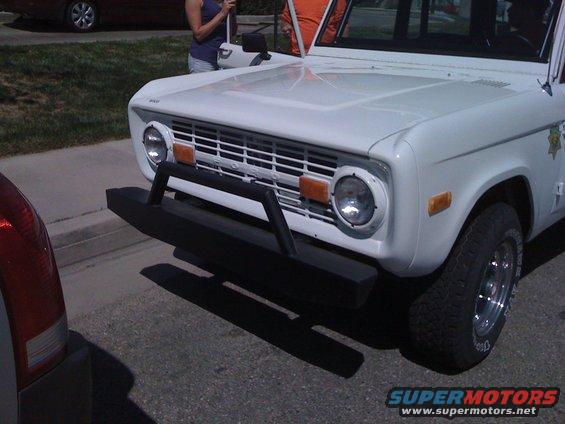 White Ford Bronco with a black bull bar on the front bumper. It has a chrome grille and round headlights