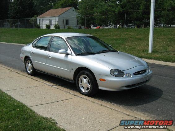 Silver sedan parked on a street, front 3/4 view