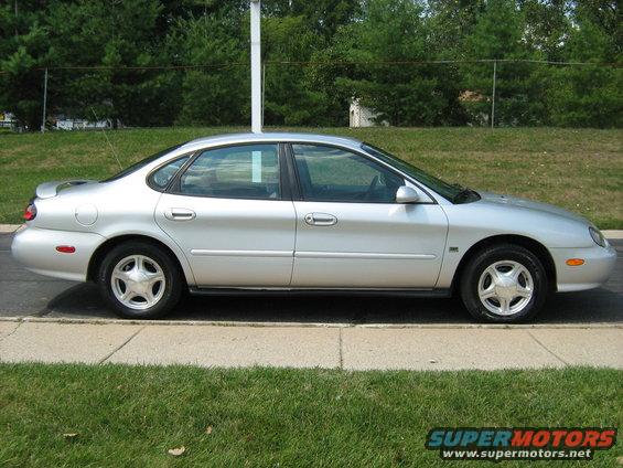 Silver sedan parked on curb, side view