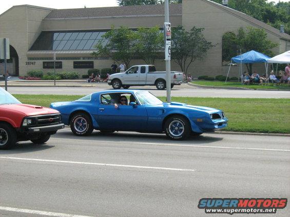 Blue 1977 Pontiac Firebird Trans Am coupe with a hood scoop and racing stripes on the side