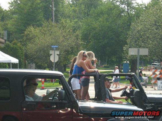 People riding in a Jeep Wrangler, some standing up