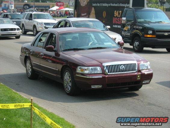 Maroon sedan with chrome grille and headlights, front view