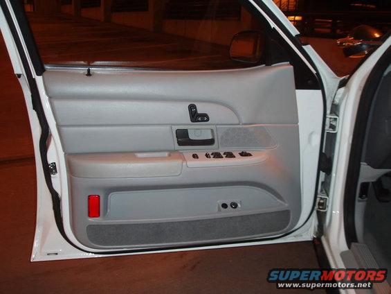 Car door panel open showing owner's manual inside door pocket